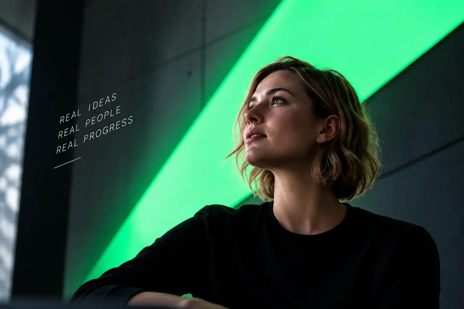 A thoughtful leader beside a vivid green architectural light